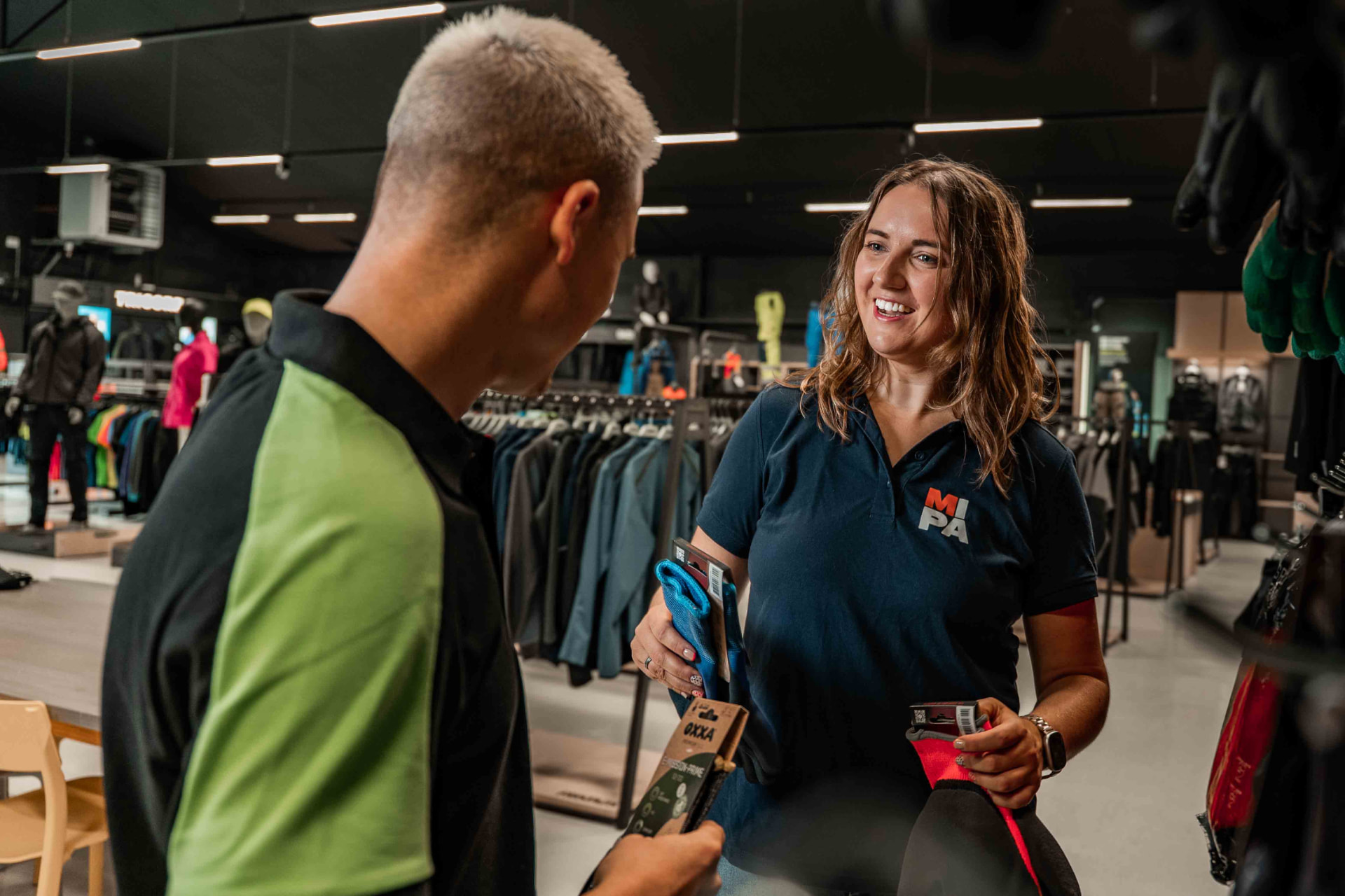 Medewerker van MIPA Bedrijfskleding adviseert een klant in de winkel in Boxmeer