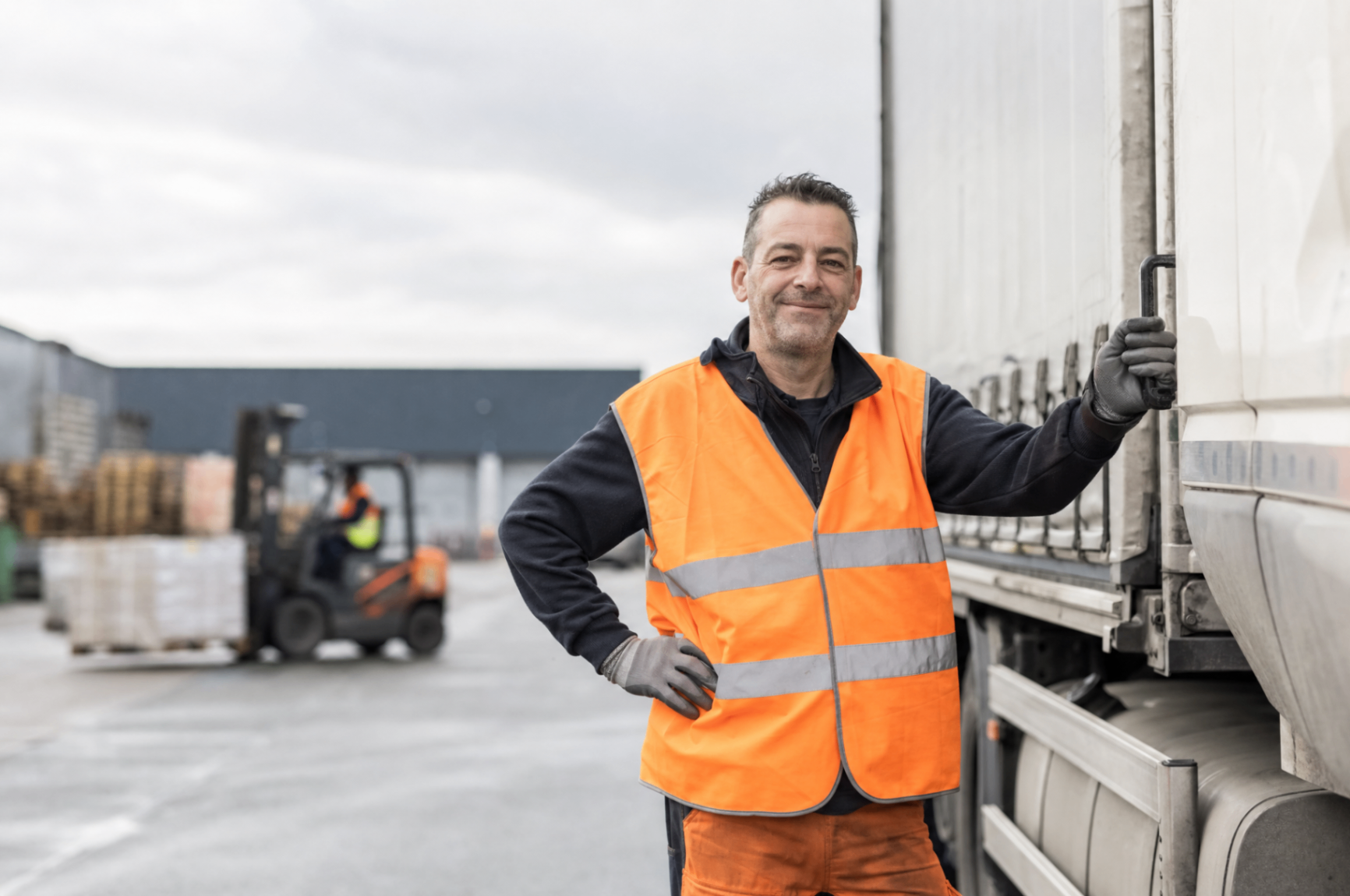 Logistiek medewerker in veiligheidskleding bij een vrachtwagen